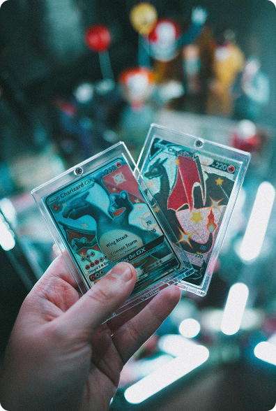 Two protected Charizard cards held up in front of festival lights